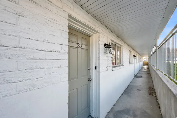 White brick exterior facade with multiple windows and exterior lighting fixtures