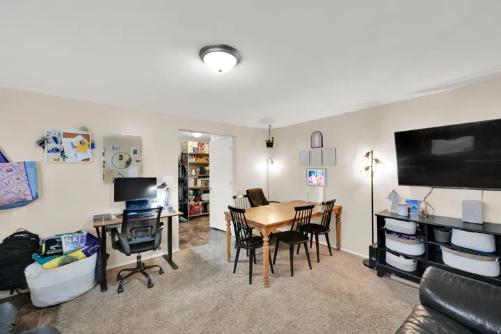 Recessed ceiling light fixture, wall-to-wall carpeting, light-toned wall paint, and a doorway leading to an interior space with built-in shelving