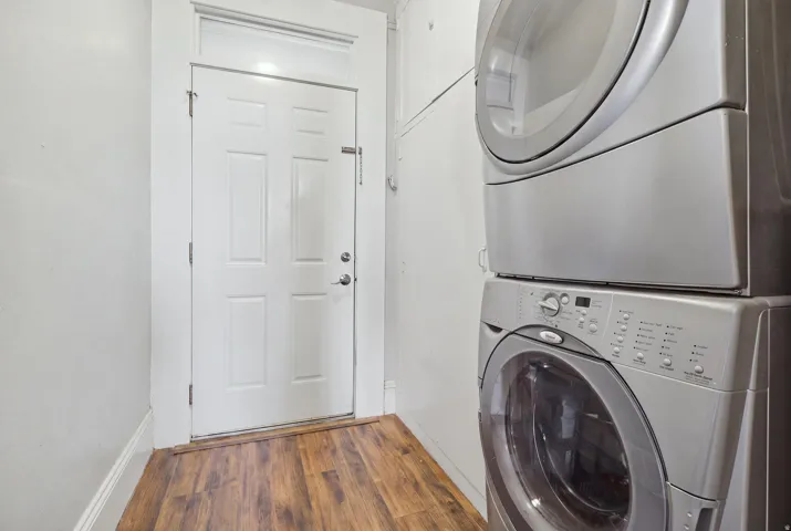Wood-finish flooring with a white paneled door and transom window