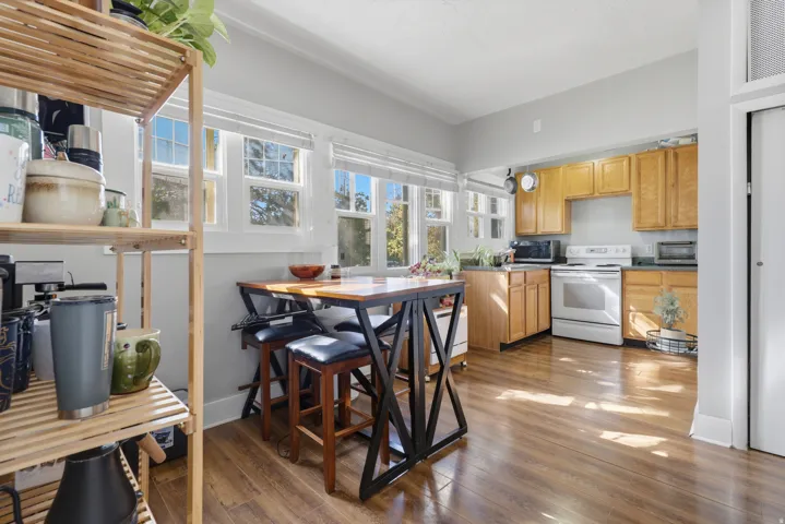 Kitchen featuring wood-finish flooring, natural wood cabinetry, a white electric range, and ample natural light from multiple windows