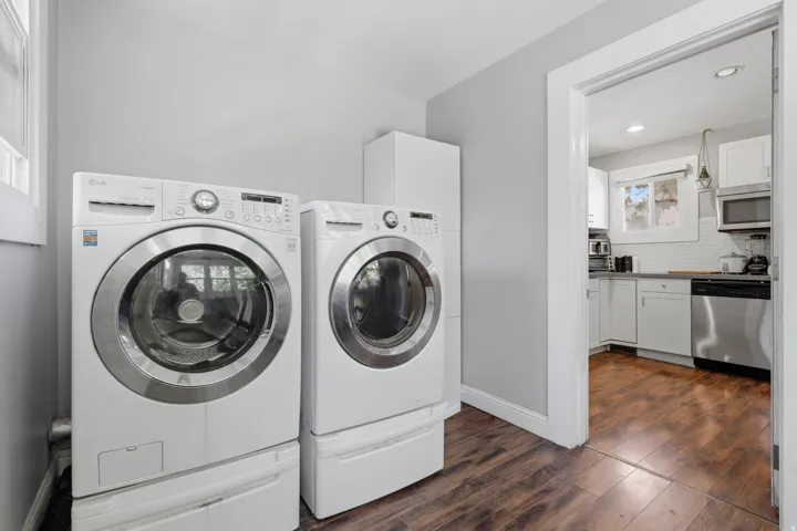 Laundry area with wood-finish flooring and a white storage cabinet
