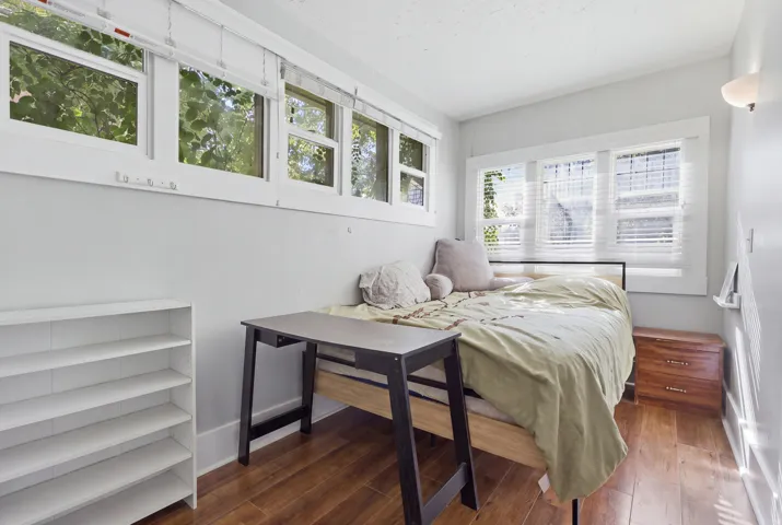 Wood-finish flooring with multiple windows and white window blinds