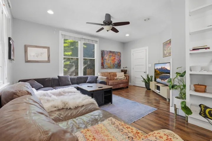 Recessed lighting, wood-finish flooring, ceiling fan, white trim work, and built-in shelving