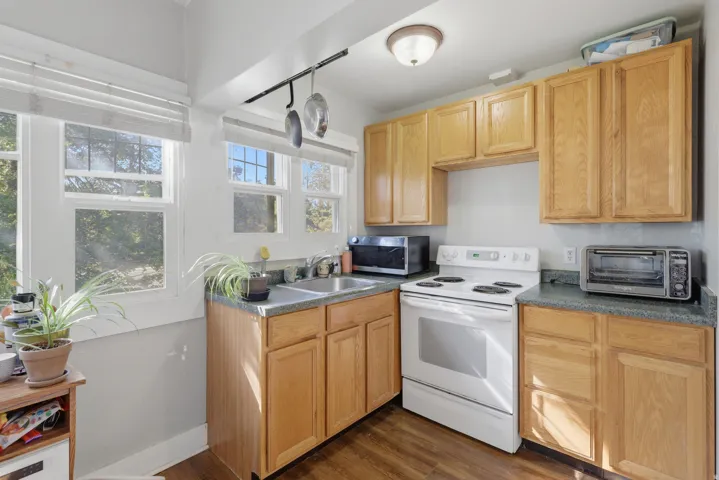 Kitchen featuring wood-finish flooring, wood cabinetry, built-in double basin sink, and multiple windows