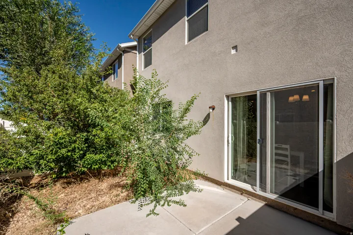 Concrete patio with sliding glass doors and stucco exterior