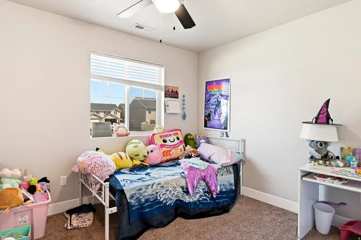 Recessed window with blinds, ceiling fan with light fixture, neutral carpet flooring, and painted walls