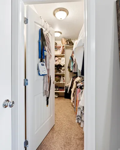 Walk-in closet featuring built-in shelving, hanging rods, and recessed lighting
