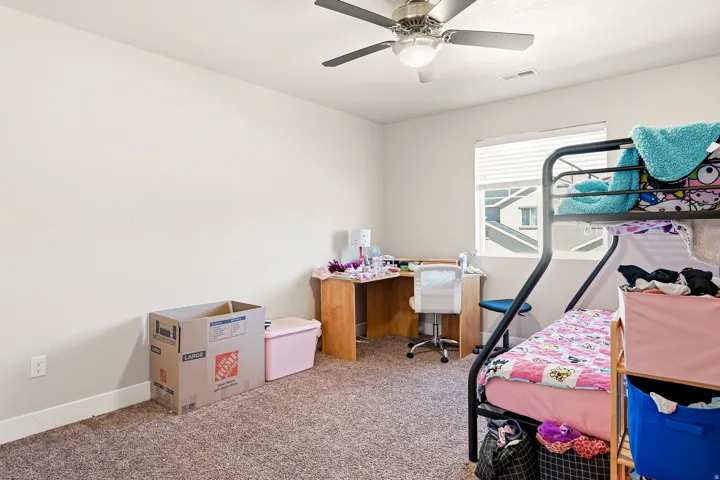Room featuring neutral wall tones, textured carpeting, a window with horizontal blinds, and an overhead ceiling fan