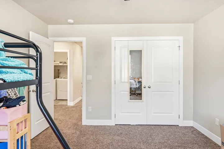 Neutral tone wall paint, textured carpet flooring, white door trim, white interior doors, and a ceiling-mounted light fixture