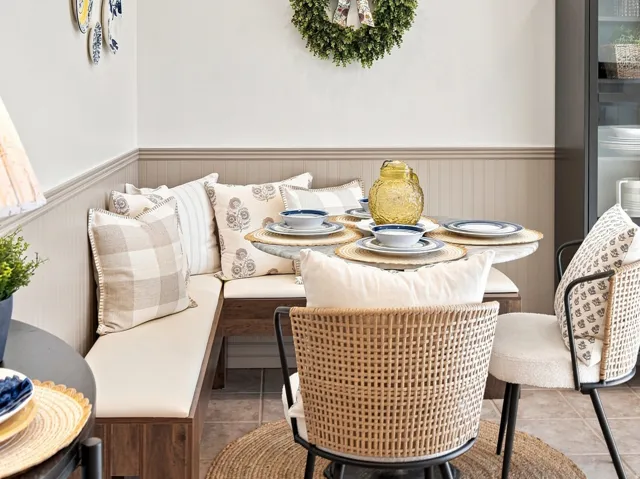 Built-in corner banquette seating with neutral cushions, wainscoting detail, recessed lighting, and tiled flooring