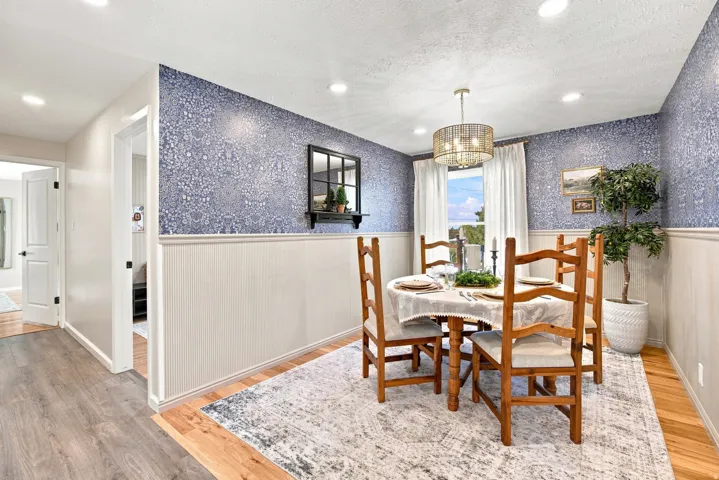 Dining space featuring wainscoting, patterned wallpaper, recessed lighting, and a drum-style chandelier