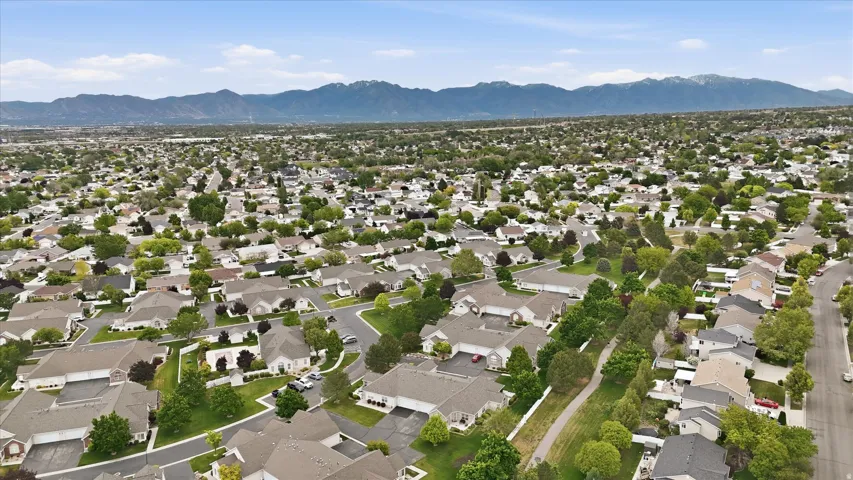 Expansive residential neighborhood with mature trees, established streets, and mountain backdrop