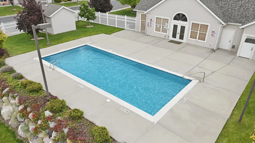 Rectangular swimming pool with concrete decking and landscaping
