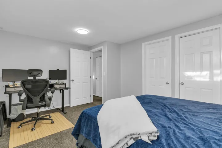 Recessed ceiling light, grey painted walls, and paneled interior doors