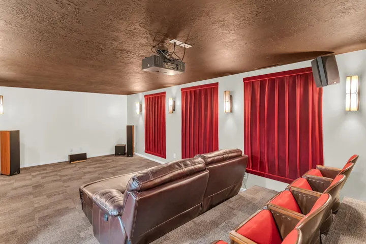 Theater room with textured ceiling, wall-mounted sconces, and acoustic paneling