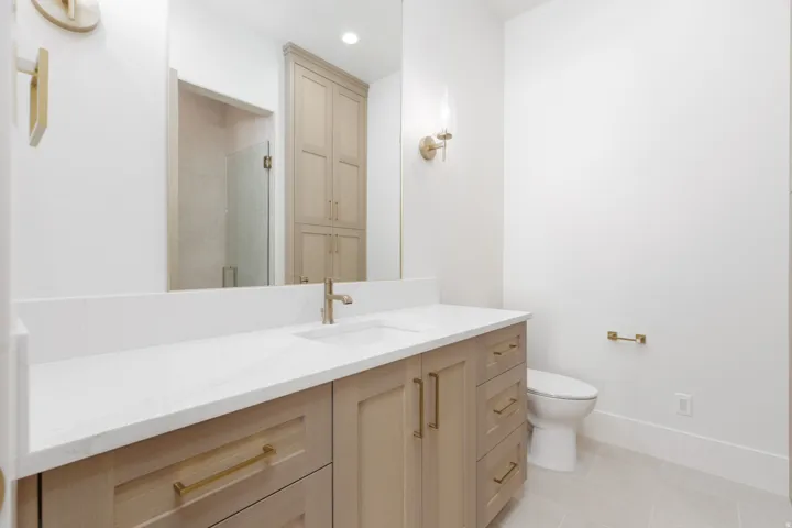 Double vanity with white countertop, integrated sink, and wood-finish cabinetry