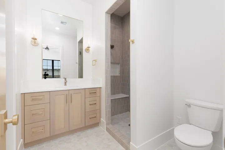 Vanity with light wood-finish cabinetry, white countertop, and gold-finish hardware