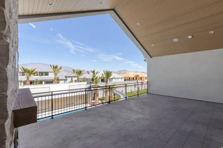 Expansive outdoor patio featuring a tiled floor, stone column, and black metal railing