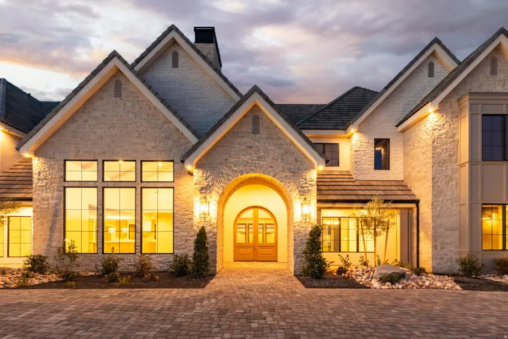 Stone and brick exterior with multiple gables and a paver driveway