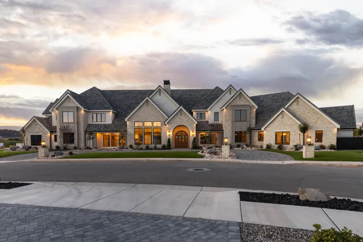 Stone veneer exterior with multiple gables and a dark shingle roof