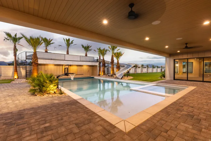 Expansive paver patio with a built-in swimming pool and integrated spa