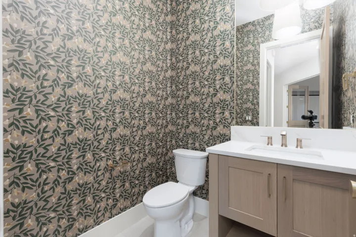 Powder room featuring a single vanity with light wood-finish cabinetry, a white countertop, and an undermount sink