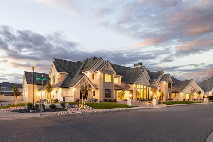 Stone and siding exterior with multiple gables and dark shingle roofing