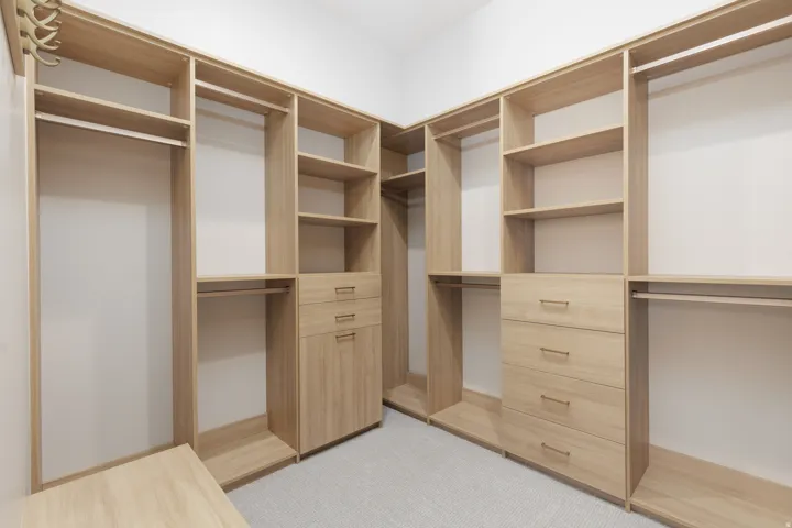 Corner closet system featuring light wood-finish cabinetry