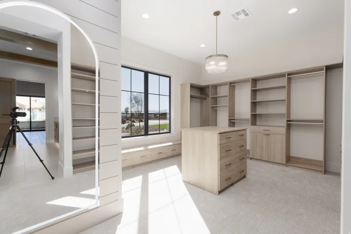 Built-in closet system with varied shelving, hanging rods, and an island with drawer storage