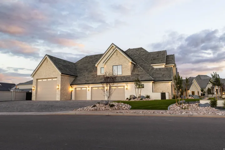 Light-toned brick exterior with dark shingle roofing