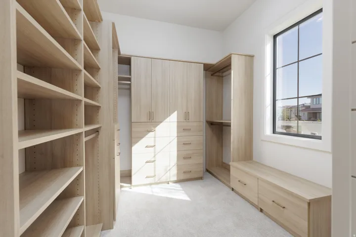 Built-in cabinetry with light wood-finish, shelving, multiple drawers, and a window with black grid panes