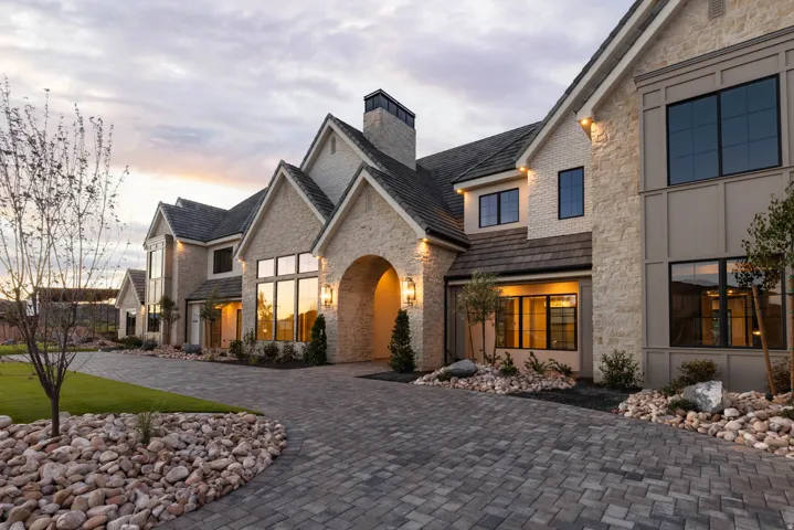 Stone veneer exterior with multiple gables and dark shingle roofing