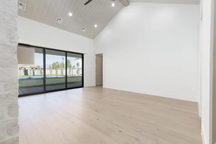Vaulted ceiling with wood-panel finish, recessed lighting, and a ceiling fan