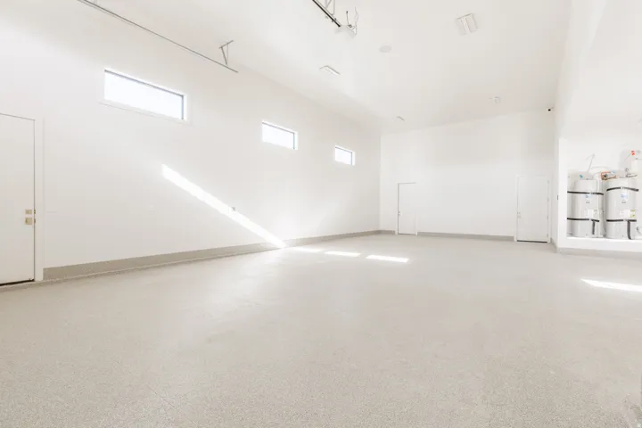 Spacious interior with an epoxy finished floor, white walls, and multiple windows