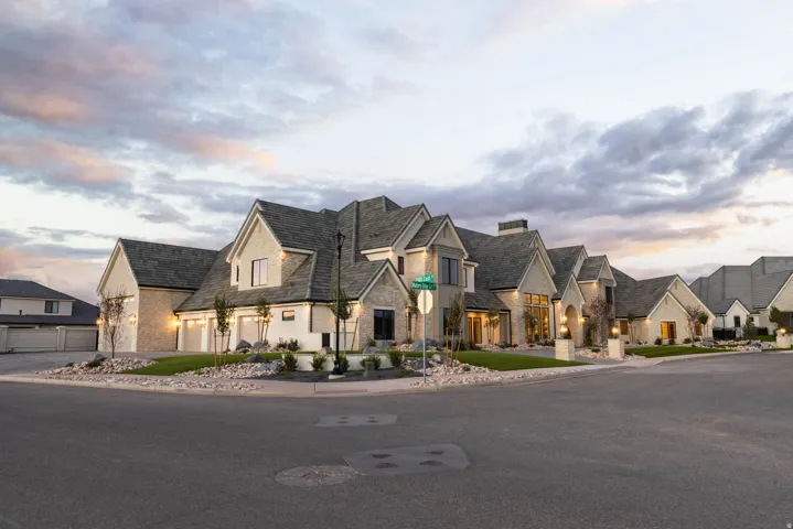 Stone and stucco exterior with multiple gables and a multi-car garage