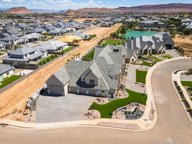Expansive property featuring a multi-car garage, stone exterior, and a large paved driveway
