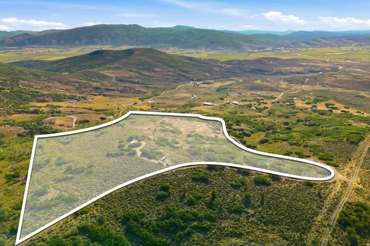 Expansive land parcel featuring natural topography, established vegetation, and distant mountain ranges