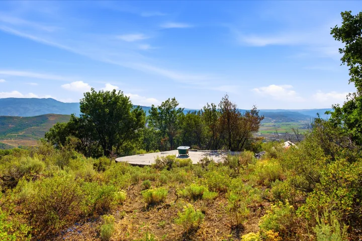 Concrete pad with surrounding natural landscaping and distant valley scenery