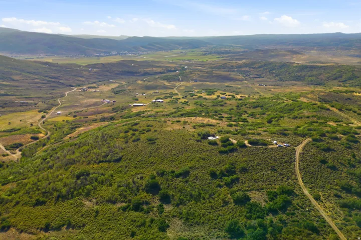 Expansive land parcel with surrounding mountains and lush vegetation