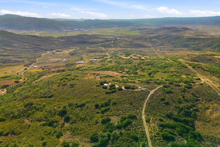Expansive terrain featuring varied vegetation, rolling hills, and distant mountains