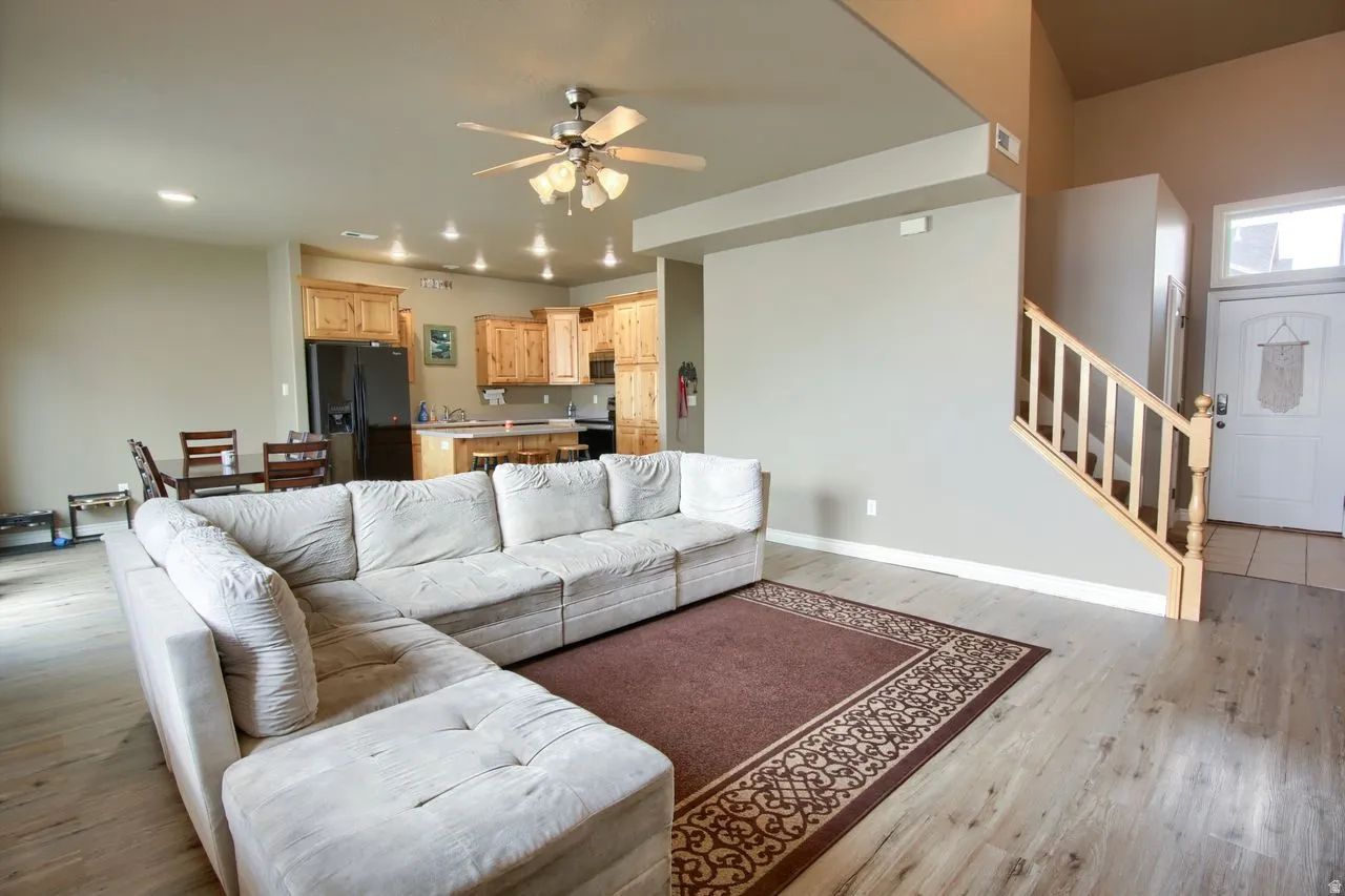 Open-concept living area featuring wood-finish flooring, a ceiling fan, and recessed lighting