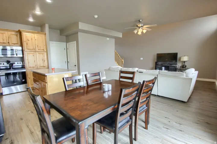 Open-concept living space with wood-finish flooring, a kitchen island, and stainless steel appliances