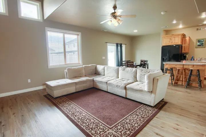 Open-concept living space featuring wood-finish flooring, recessed lighting, and a ceiling fan