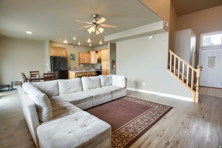 Open-concept living area featuring wood-finish flooring, a ceiling fan, and recessed lighting