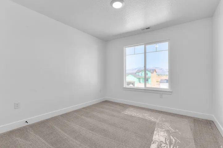 White interior walls, recessed ceiling light, and a large window