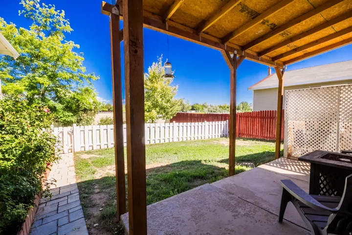 Covered patio with a concrete surface, supported by exposed wood beams