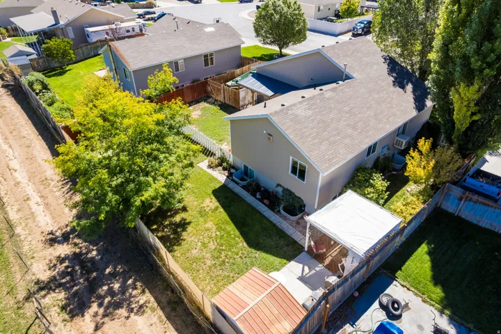 Expansive backyard featuring a concrete patio, covered pergola, and mature trees