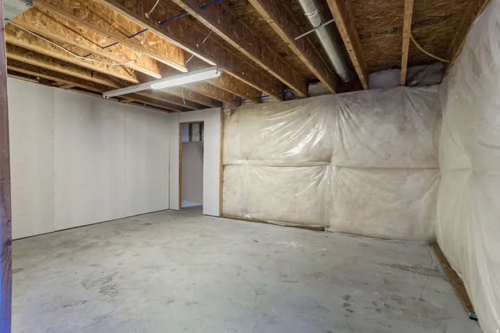 Exposed ceiling joists with visible electrical and plumbing lines