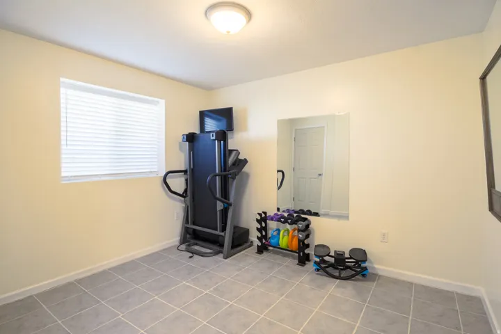 Recessed lighting, window with blinds, light-toned walls, and grey tile flooring