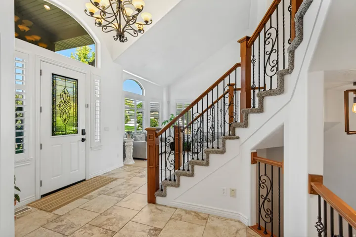 Two-story foyer with tiled flooring and decorative chandelier